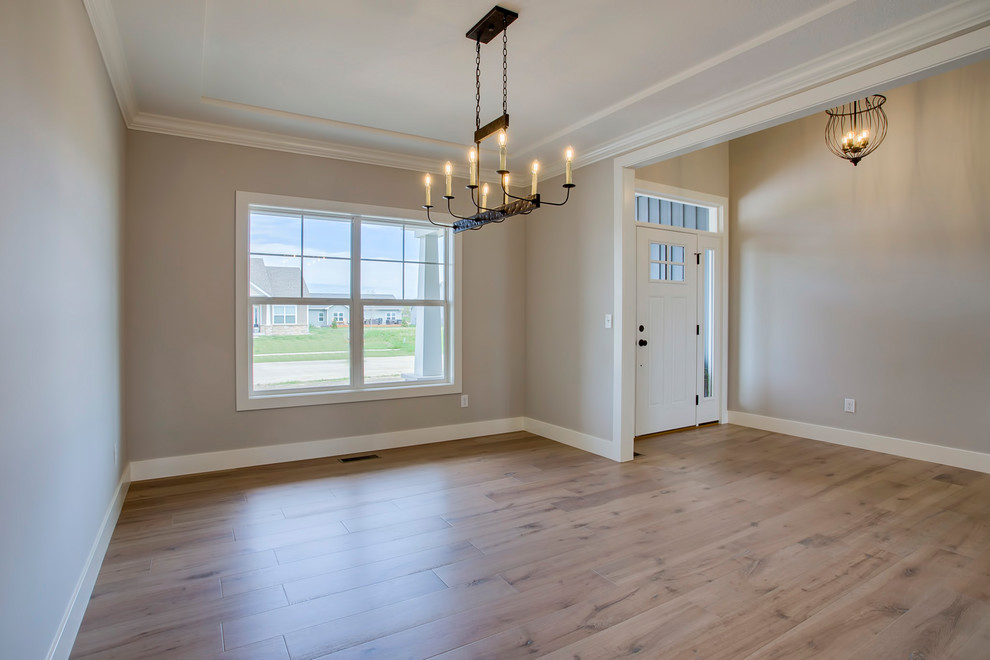 Photo of a medium sized country enclosed dining room in Chicago with grey walls, light hardwood flooring and beige floors.