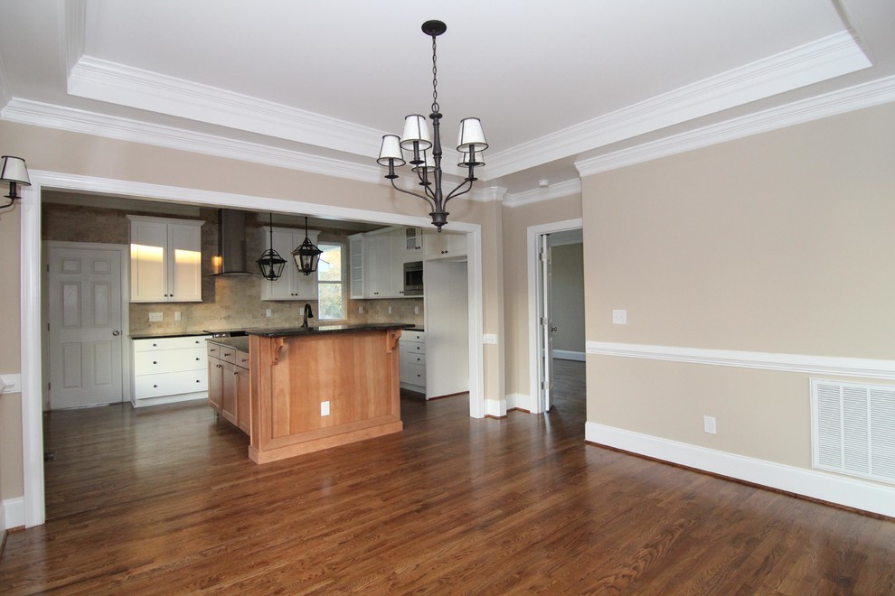 Cette photo montre une salle à manger ouverte sur la cuisine craftsman de taille moyenne avec un mur beige et un sol en bois brun.