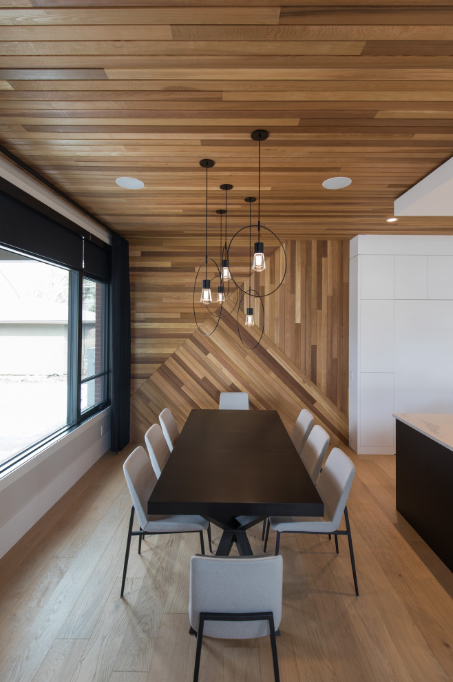 Große Moderne Wohnküche ohne Kamin mit brauner Wandfarbe, Holzdecke, Holzwänden und hellem Holzboden in Calgary