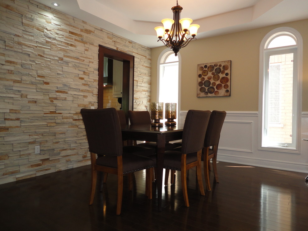 Immagine di una sala da pranzo aperta verso il soggiorno tradizionale di medie dimensioni con pareti gialle e parquet scuro