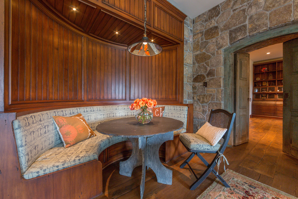 Immagine di una sala da pranzo aperta verso la cucina stile rurale di medie dimensioni con pareti marroni, pavimento in legno massello medio e nessun camino