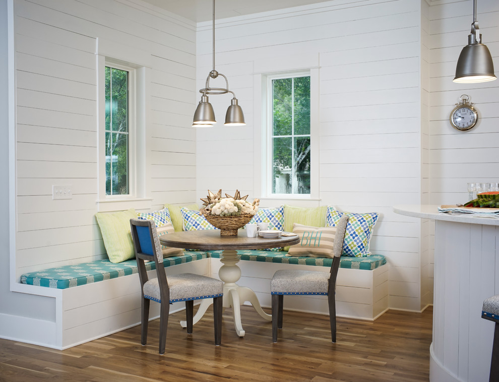 Inspiration pour une salle à manger ouverte sur la cuisine marine avec un mur blanc, un sol en bois brun et aucune cheminée.