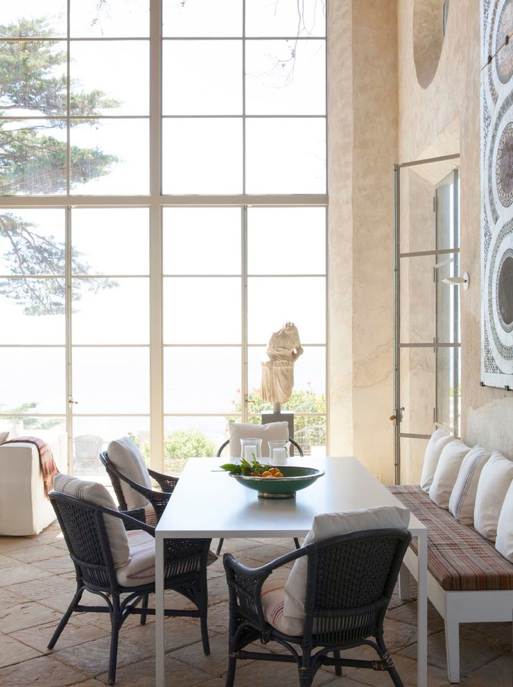 Пример оригинального дизайна: большая гостиная-столовая в средиземноморском стиле с бежевыми стенами и полом из известняка