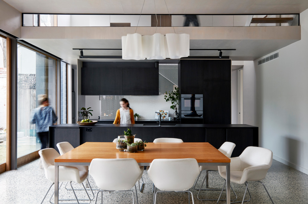 Esempio di una grande sala da pranzo aperta verso il soggiorno minimal con pavimento in cemento, pavimento grigio e pareti bianche