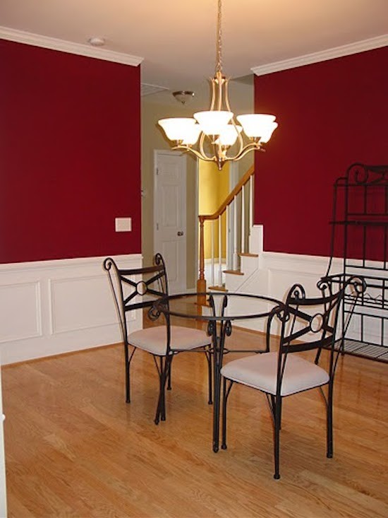 Immagine di una sala da pranzo aperta verso la cucina di medie dimensioni con pareti rosse, pavimento in legno massello medio e nessun camino