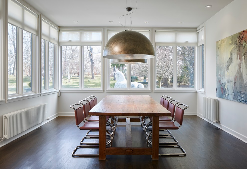 Idée de décoration pour une salle à manger design avec un mur blanc, parquet foncé et un sol marron.
