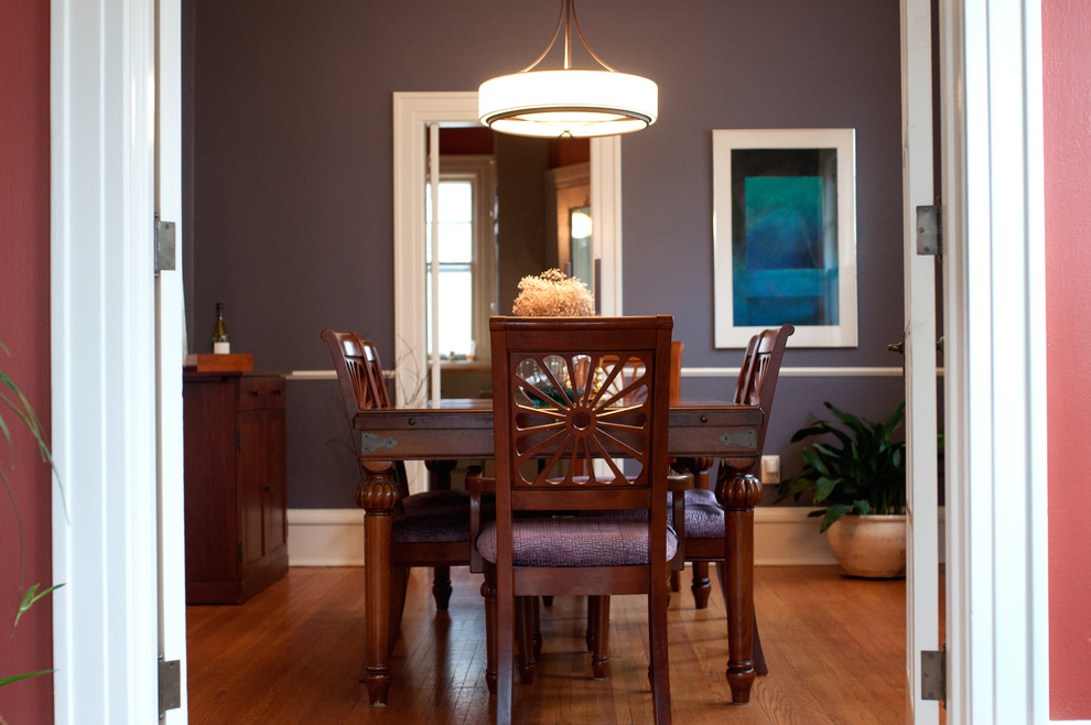 Esempio di una sala da pranzo chic chiusa e di medie dimensioni con pareti viola e parquet chiaro