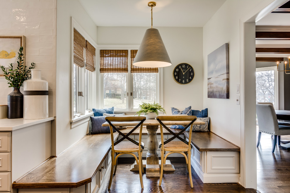 Idées déco pour une salle à manger ouverte sur la cuisine classique avec un mur blanc, parquet foncé et un sol marron.
