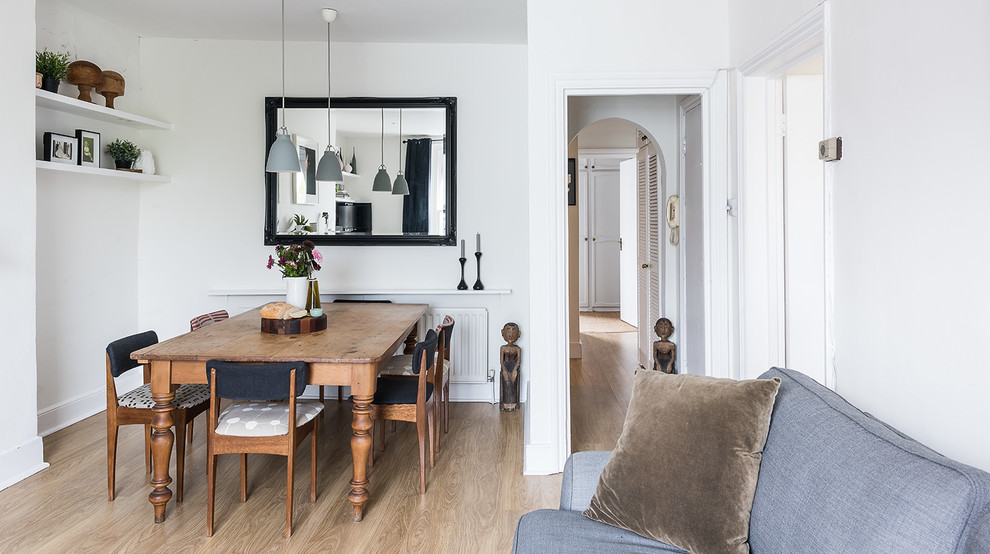Design ideas for a scandinavian dining room in London with white walls and medium hardwood flooring.
