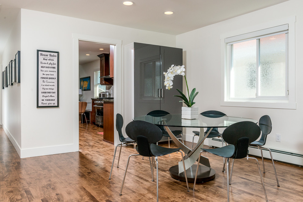 Moderne Wohnküche mit weißer Wandfarbe und braunem Holzboden in Vancouver