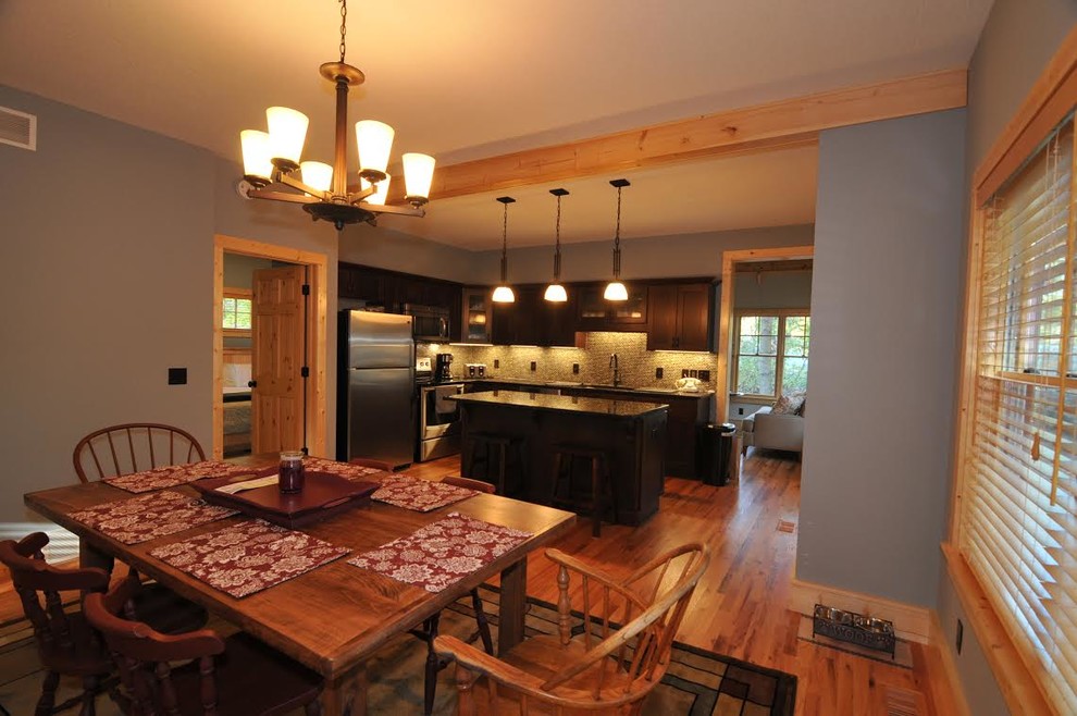 Inspiration pour une salle à manger ouverte sur la cuisine craftsman de taille moyenne avec un mur bleu, un sol en bois brun et aucune cheminée.
