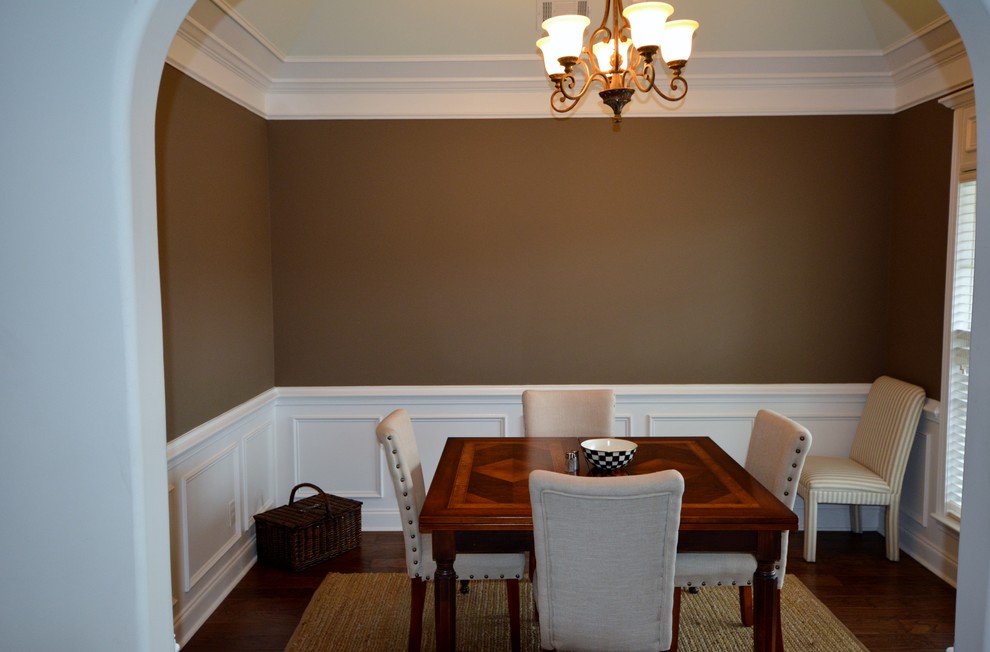 Réalisation d'une petite salle à manger design fermée avec un mur marron et un sol en bois brun.