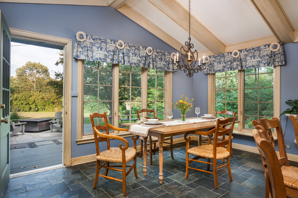 Inspiration pour une salle à manger ouverte sur la cuisine rustique de taille moyenne avec un mur bleu, un sol en ardoise et aucune cheminée.