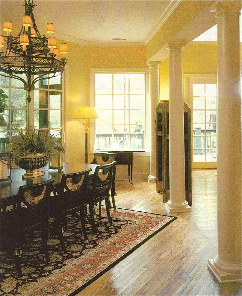 Offenes, Großes Esszimmer mit beiger Wandfarbe und braunem Holzboden in Charleston