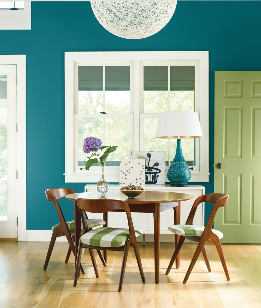 Foto de comedor de cocina ecléctico de tamaño medio sin chimenea con paredes azules, suelo de madera clara y suelo beige