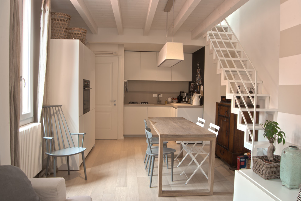 Exempel på en liten minimalistisk matplats med öppen planlösning, med beige väggar, ljust trägolv och beiget golv