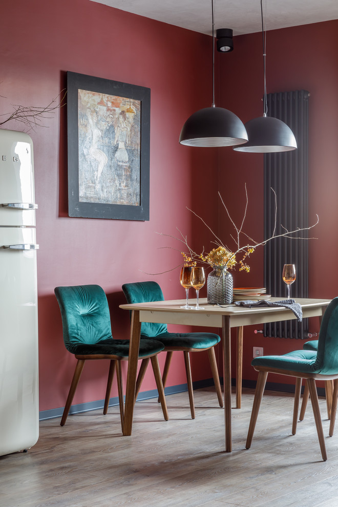 Imagen de comedor actual con paredes rojas, suelo de madera en tonos medios y suelo beige