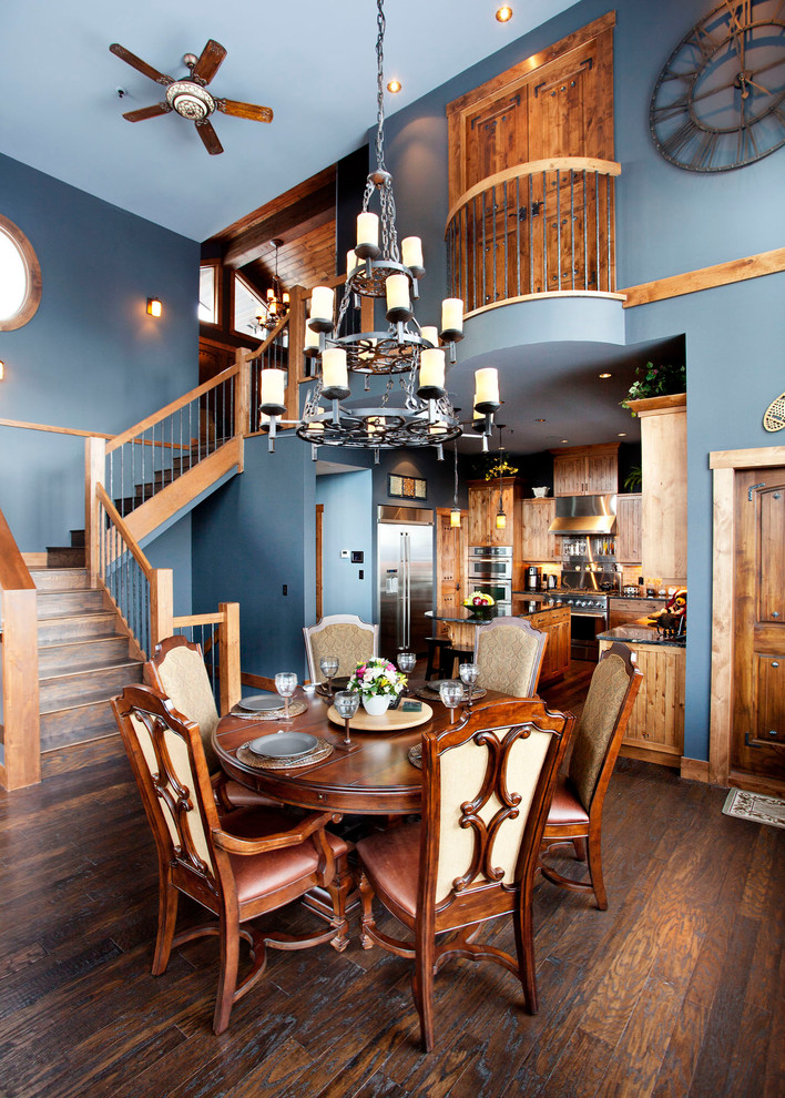 Cette image montre une salle à manger chalet avec un mur bleu et parquet foncé.