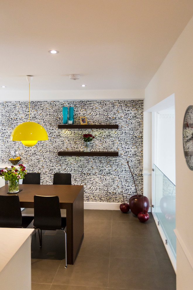 Photo of a contemporary dining room in London with white walls and a feature wall.