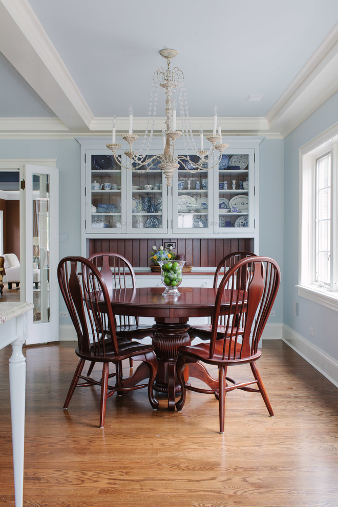 Example of a large classic medium tone wood floor kitchen/dining room combo design in Chicago with blue walls and no fireplace