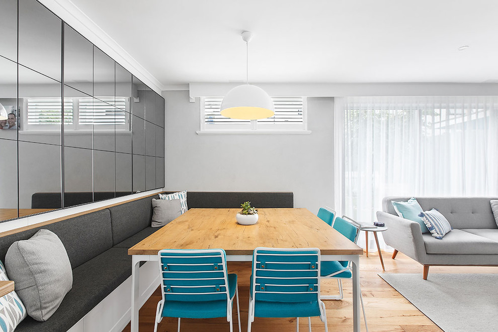Foto di una sala da pranzo aperta verso la cucina design con pareti grigie, pavimento in legno massello medio e pavimento marrone