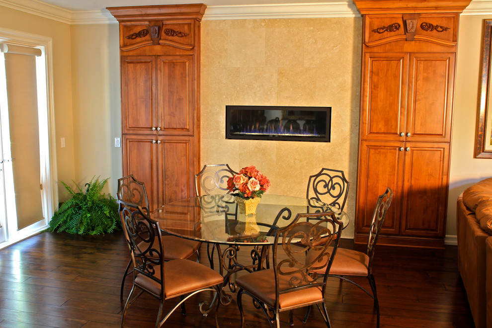 Cette image montre une salle à manger ouverte sur le salon de taille moyenne avec un mur beige, parquet foncé, une cheminée ribbon et un manteau de cheminée en carrelage.