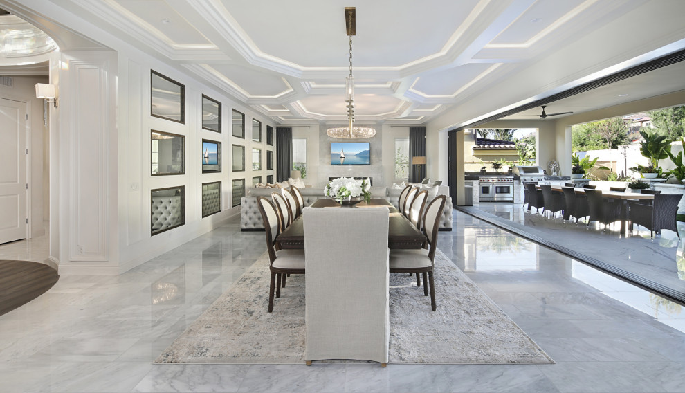 Réalisation d'une grande salle à manger ouverte sur le salon design avec un mur blanc, un sol en marbre et un sol gris.