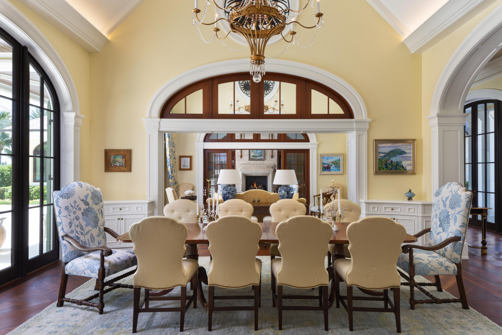 Geschlossenes Klassisches Esszimmer ohne Kamin mit gelber Wandfarbe, braunem Holzboden, braunem Boden und gewölbter Decke in Miami