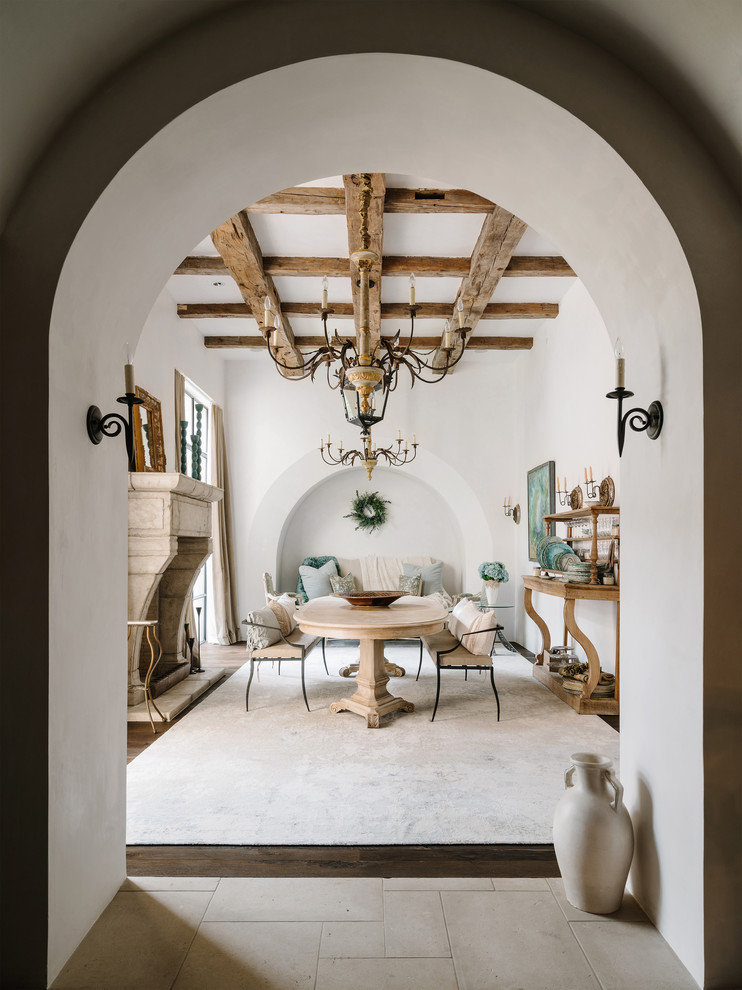 Источник вдохновения для домашнего уюта: отдельная столовая в средиземноморском стиле с белыми стенами, темным паркетным полом и стандартным камином