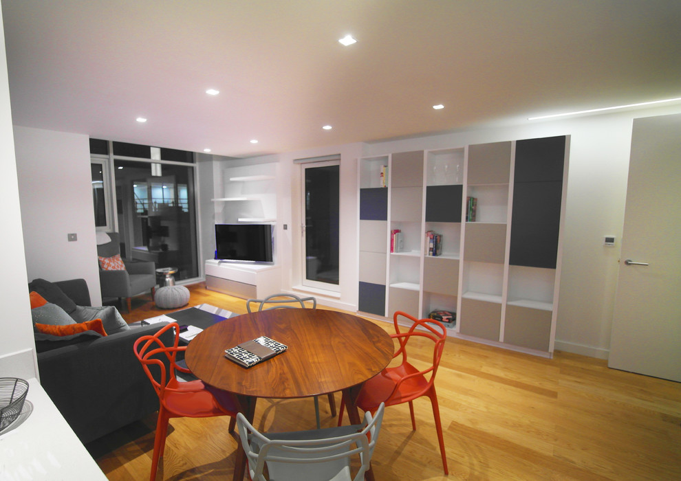 Photo of a medium sized contemporary dining room in London with white walls, light hardwood flooring and no fireplace.