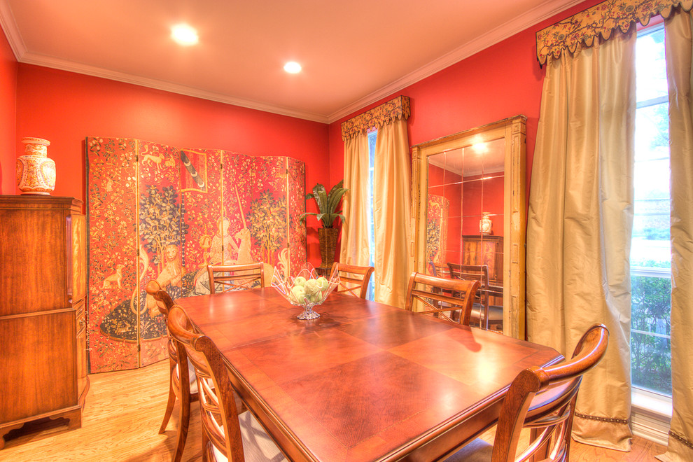 Ispirazione per una sala da pranzo aperta verso la cucina chic di medie dimensioni con pareti rosse e pavimento in laminato