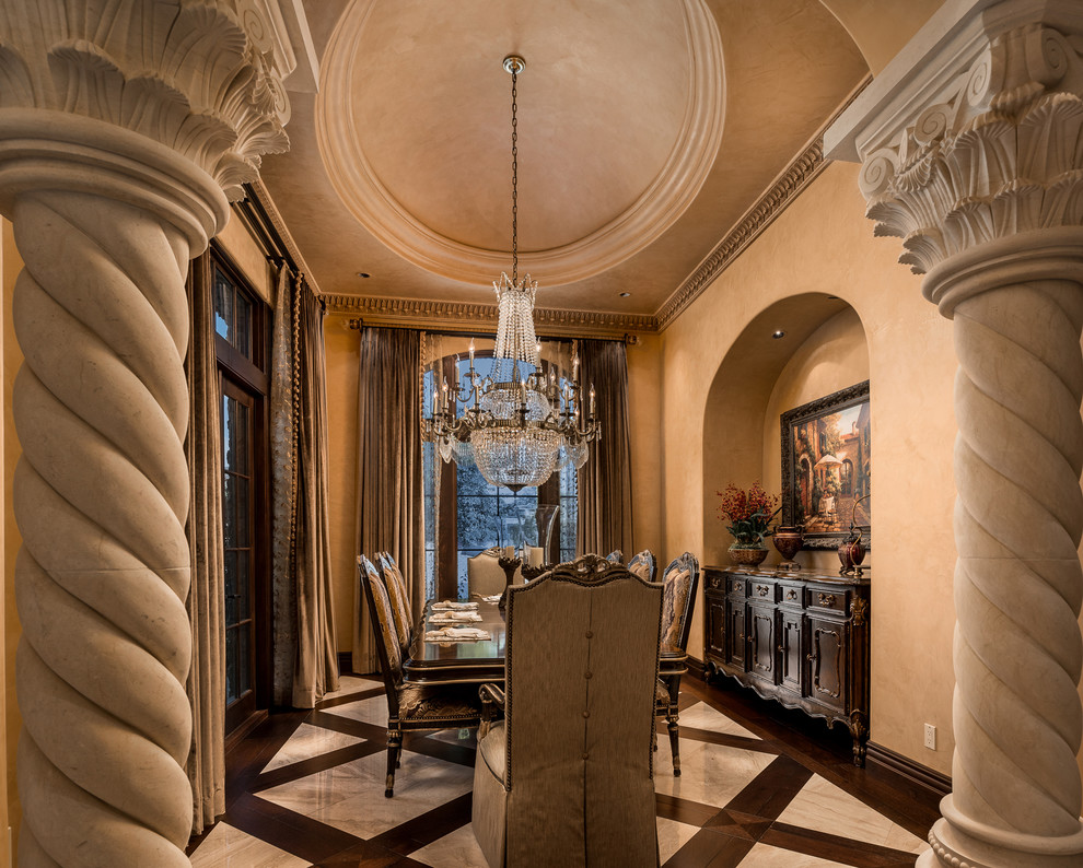Photo of an expansive classic enclosed dining room in Phoenix with beige walls, marble flooring, a standard fireplace, a stone fireplace surround and beige floors.