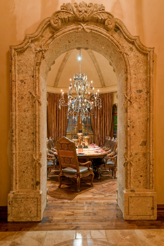 Cette image montre une très grande salle à manger méditerranéenne fermée avec un mur beige, un sol en bois brun et aucune cheminée.