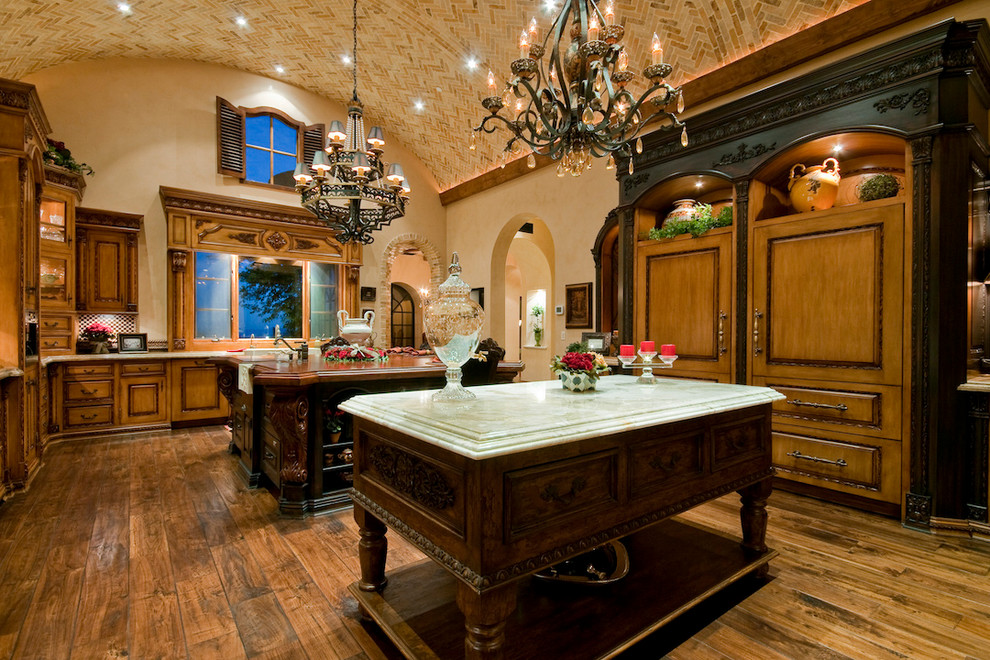 Exempel på ett avskilt, mycket stort medelhavsstil u-kök, med mellanmörkt trägolv, en rustik diskho, luckor med infälld panel, skåp i mellenmörkt trä, granitbänkskiva, beige stänkskydd, stänkskydd i mosaik, rostfria vitvaror och flera köksöar