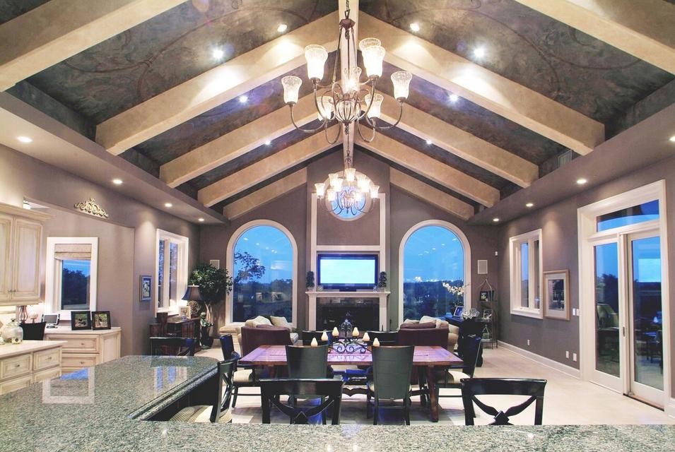 Пример оригинального дизайна: огромная гостиная-столовая в стиле неоклассика (современная классика) с фиолетовыми стенами, светлым паркетным полом, стандартным камином и фасадом камина из дерева