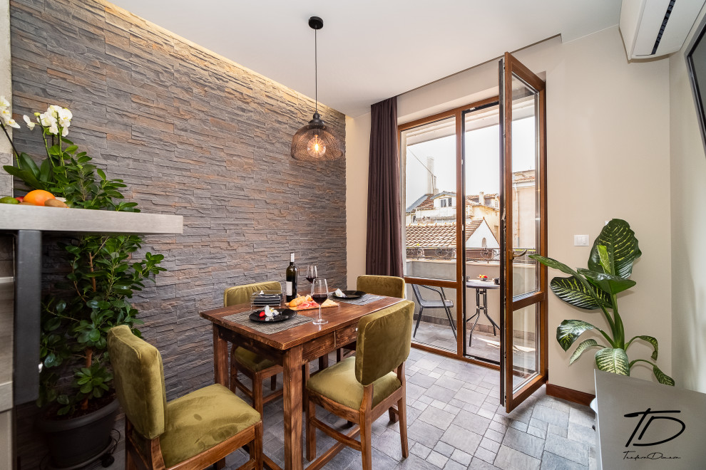 Immagine di una piccola sala da pranzo aperta verso la cucina industriale con pareti beige, pavimento in terracotta, pavimento grigio e pareti in mattoni