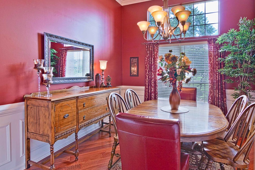 Mid-sized elegant medium tone wood floor dining room photo in Jacksonville with red walls