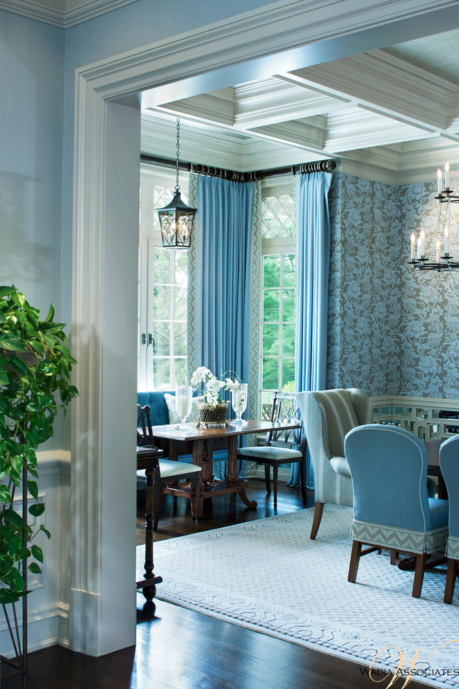 Cette image montre une grande salle à manger traditionnelle avec un mur bleu, parquet foncé et éclairage.