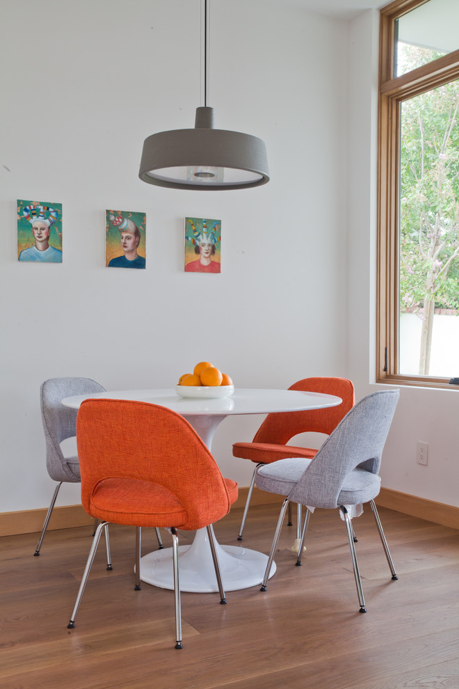 Example of a trendy medium tone wood floor dining room design in Los Angeles with white walls