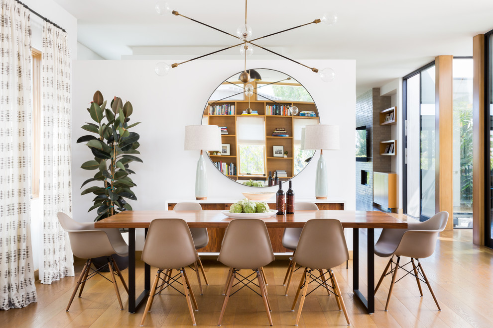 Inspiration for a medium sized contemporary open plan dining room in Los Angeles with white walls, medium hardwood flooring, brown floors, no fireplace and feature lighting.