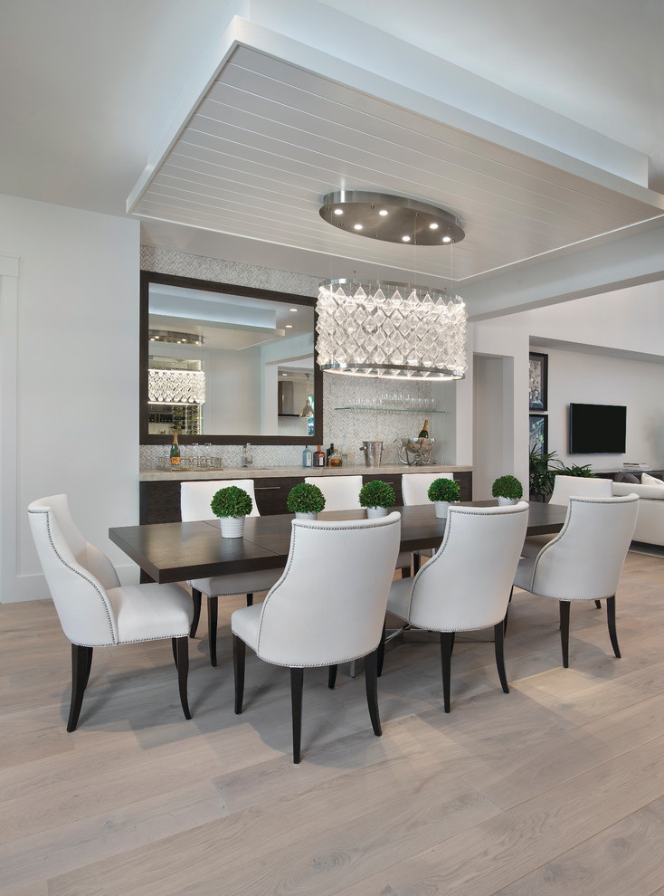Aménagement d'une grande salle à manger ouverte sur la cuisine contemporaine avec un mur gris et parquet clair.