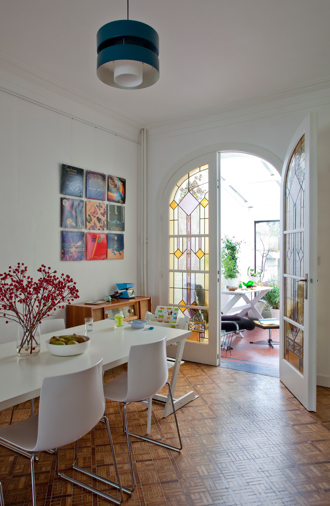 Stilmix Esszimmer mit weißer Wandfarbe und braunem Holzboden in Sonstige