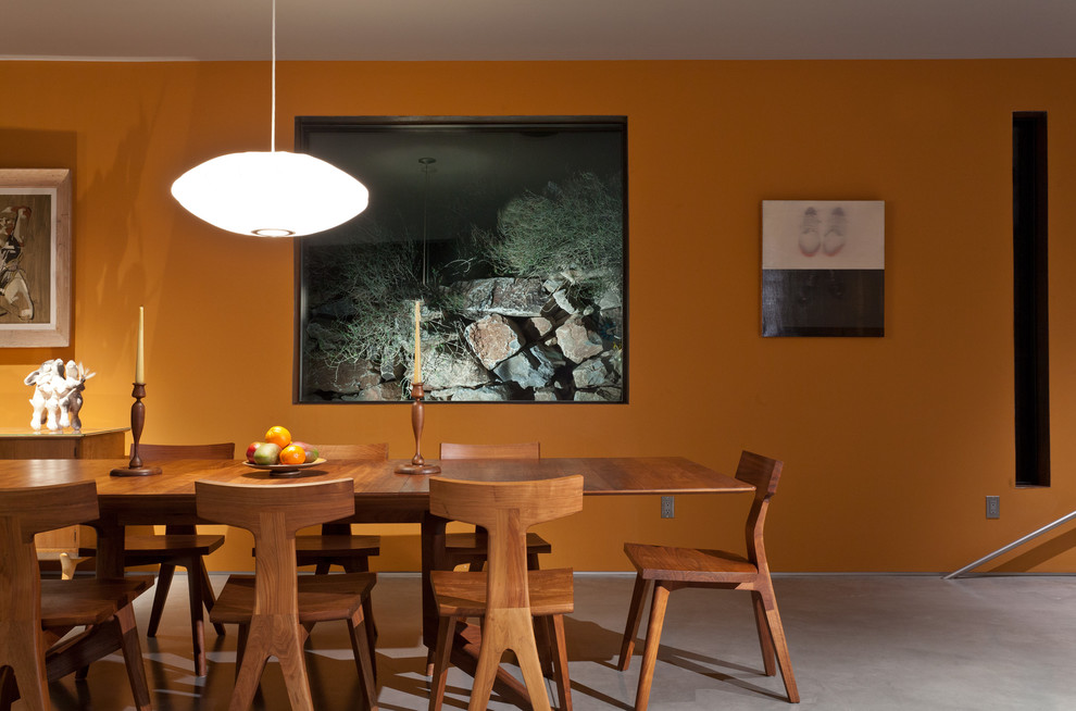 Immagine di una sala da pranzo minimalista con pavimento in cemento
