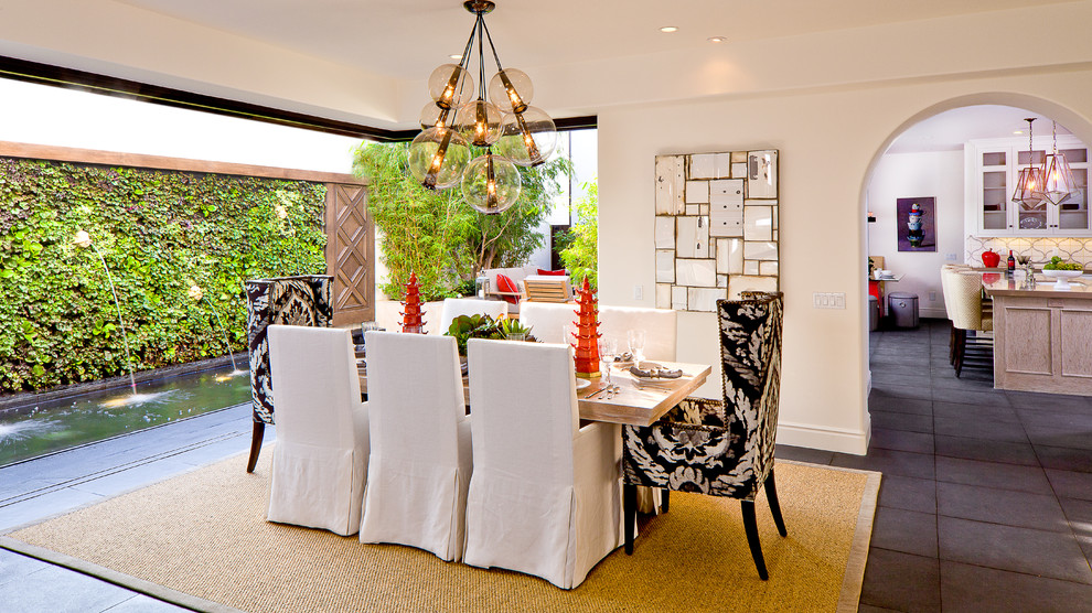 Immagine di una sala da pranzo mediterranea di medie dimensioni con pareti bianche, pavimento in ardesia e nessun camino