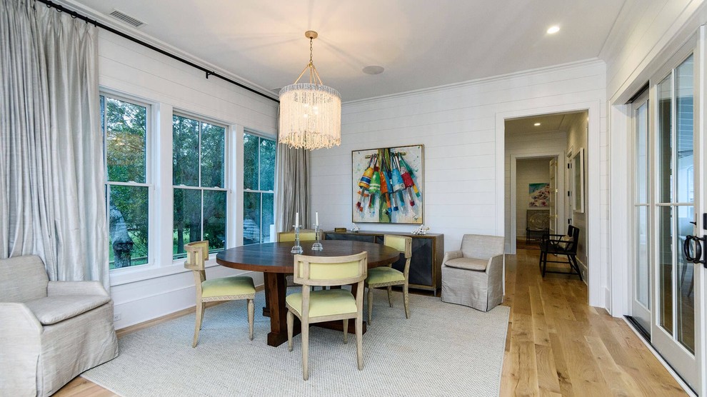 Photo of a medium sized beach style enclosed dining room in Charleston with white walls, medium hardwood flooring, no fireplace and brown floors.