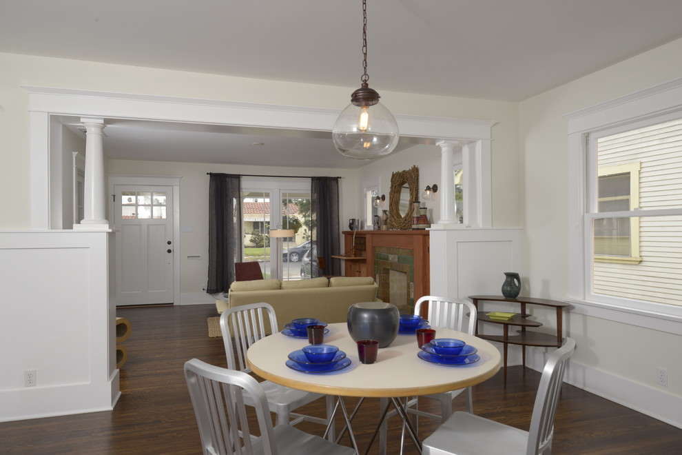 Aménagement d'une salle à manger ouverte sur la cuisine craftsman de taille moyenne avec un mur blanc et parquet foncé.