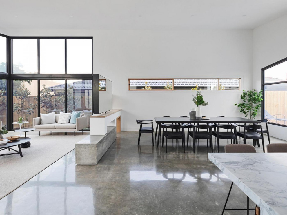 Ispirazione per una sala da pranzo aperta verso il soggiorno minimal con pareti bianche, pavimento in cemento e pavimento grigio