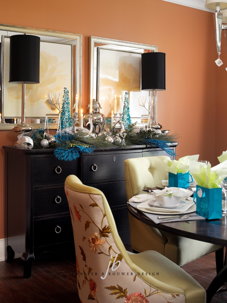 На фото: отдельная столовая среднего размера в стиле неоклассика (современная классика) с оранжевыми стенами и темным паркетным полом