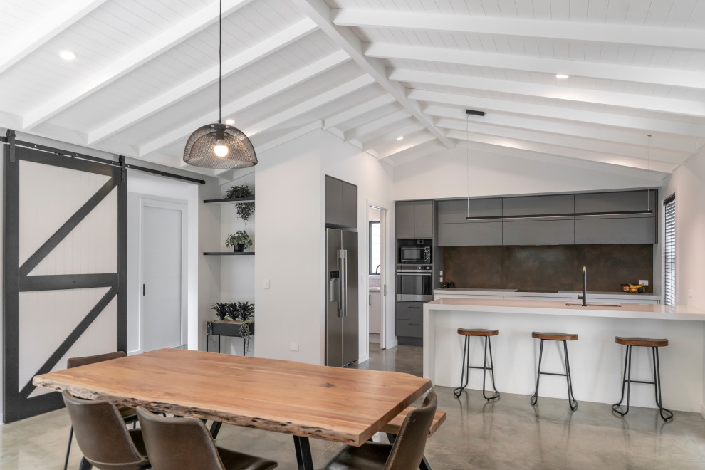 Aménagement d'une salle à manger ouverte sur la cuisine moderne de taille moyenne avec un sol gris.