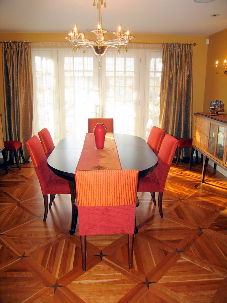 Immagine di una grande sala da pranzo aperta verso la cucina contemporanea con pareti gialle, pavimento in legno massello medio e nessun camino